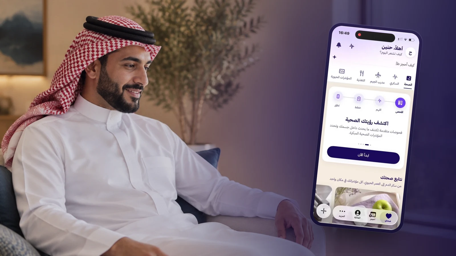 رجل سعودي يجلس مرتاحًا قرب نافذة مضيئة في منزل عصري وينظر إلى شاشة تطبيق وِل، وتظهر الشاشة «اكتشف رؤيتك الصحية» مع مسار الفحص والخطط ومتابعة المؤشرات الحيوية.